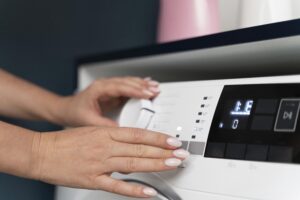 Person choosing a program on a washing machine, illustrating an LG reset procedure
