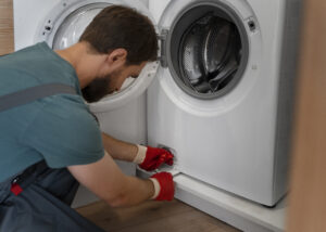 Technician working on a washing machine, illustrating a leveling and balance check