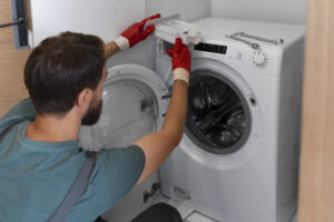 Technician inspecting a washing machine during a repair diagnosis