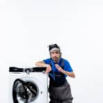 Repairman sitting near a washing machine using a stethoscope, illustrating Bosch washer error code E18 drain timeout