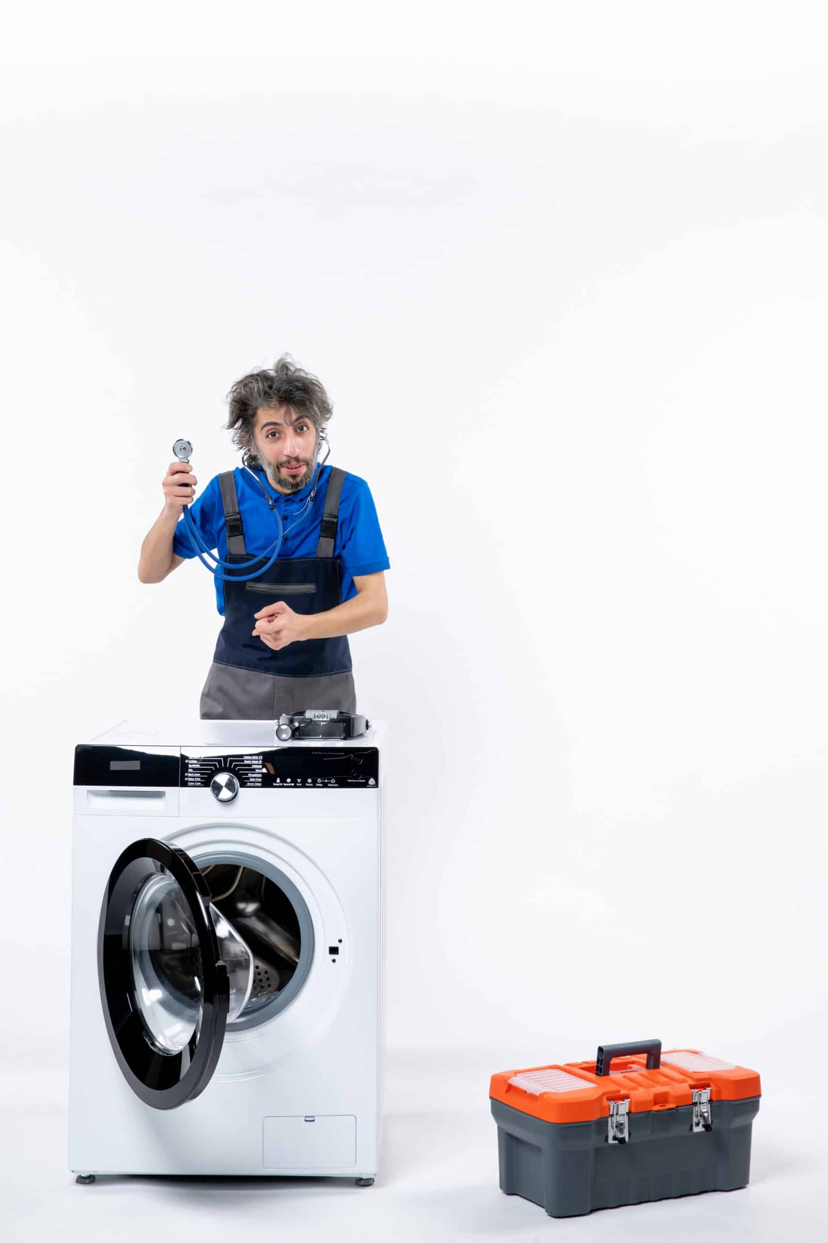 Repair technician pointing at a front-load washing machine while diagnosing a GE washer E2 drain error