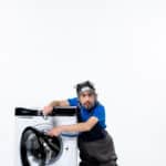 Repairman opening a washing machine, illustrating Maytag washer error code Sud excessive suds fault