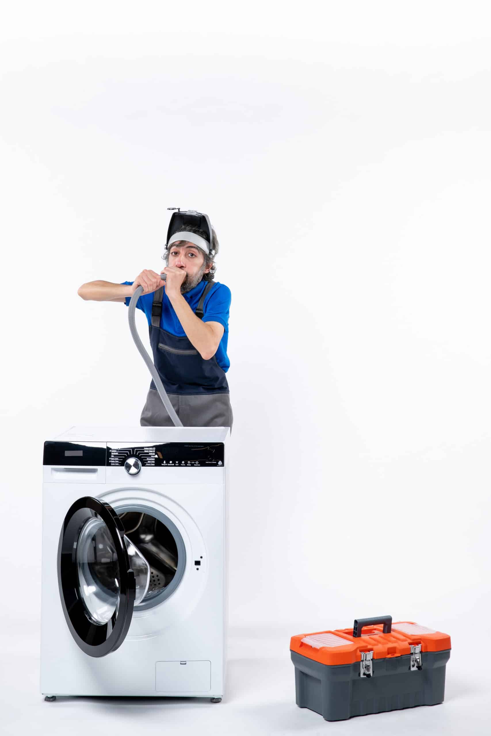 Repairman in uniform standing behind a washing machine blowing out a pipe, illustrating Samsung washer error code UE unbalanced load
