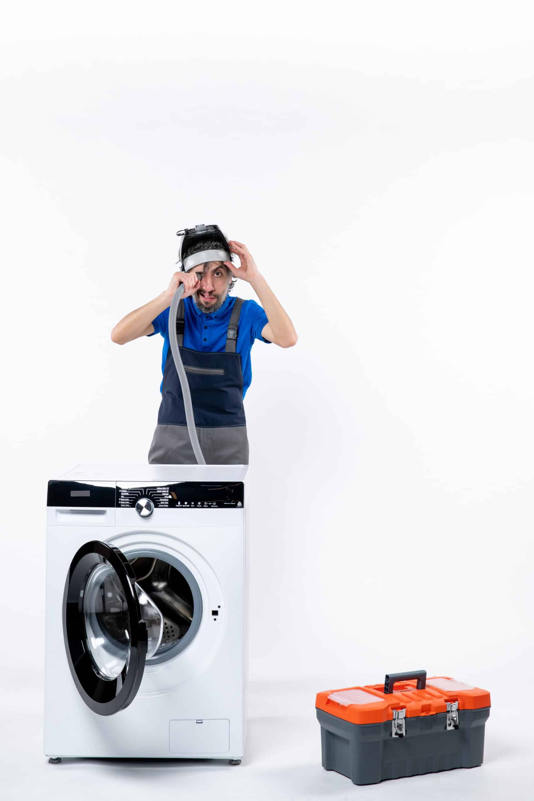 Young repairman in uniform servicing a washing machine with a tools bag, illustrating LG washer error code UE unbalanced load