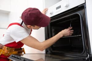 Technician repairing a Whirlpool oven that stopped heating