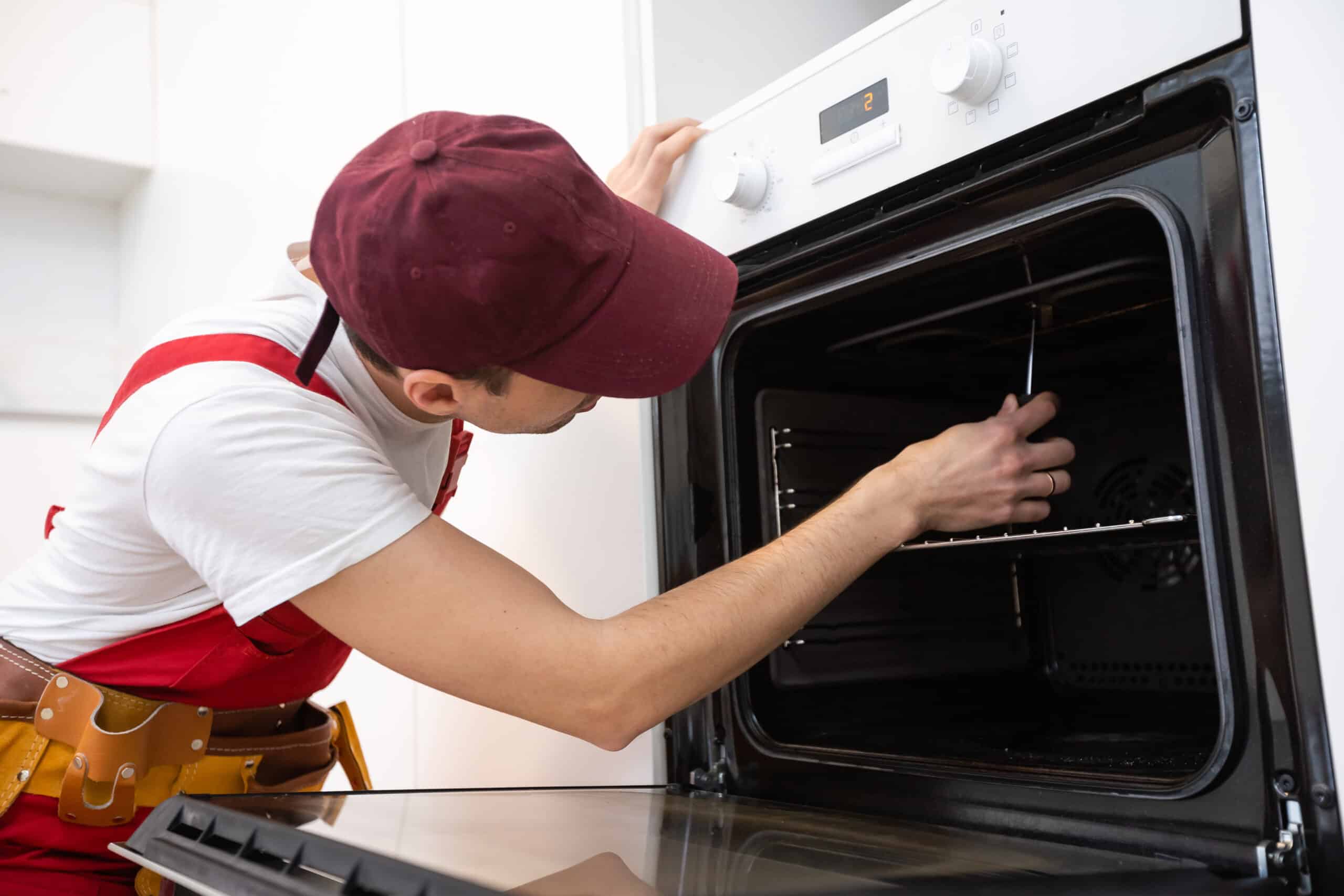 Technician repairing a Whirlpool oven that stopped heating