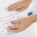 Woman programming a washing machine control panel