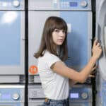Femme fermant la porte d'un lave-linge