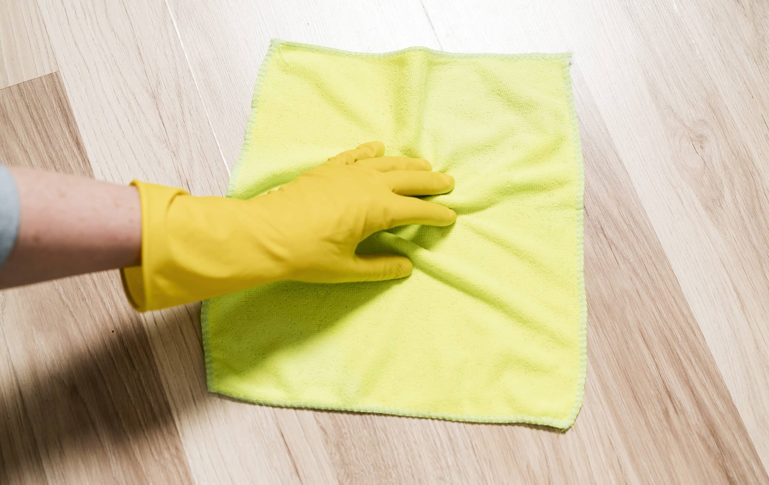 Person wiping up a water leak from the kitchen floor, illustrating Whirlpool dishwasher error code F2 leak detected
