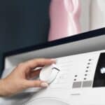 Woman choosing a wash program on a washing machine