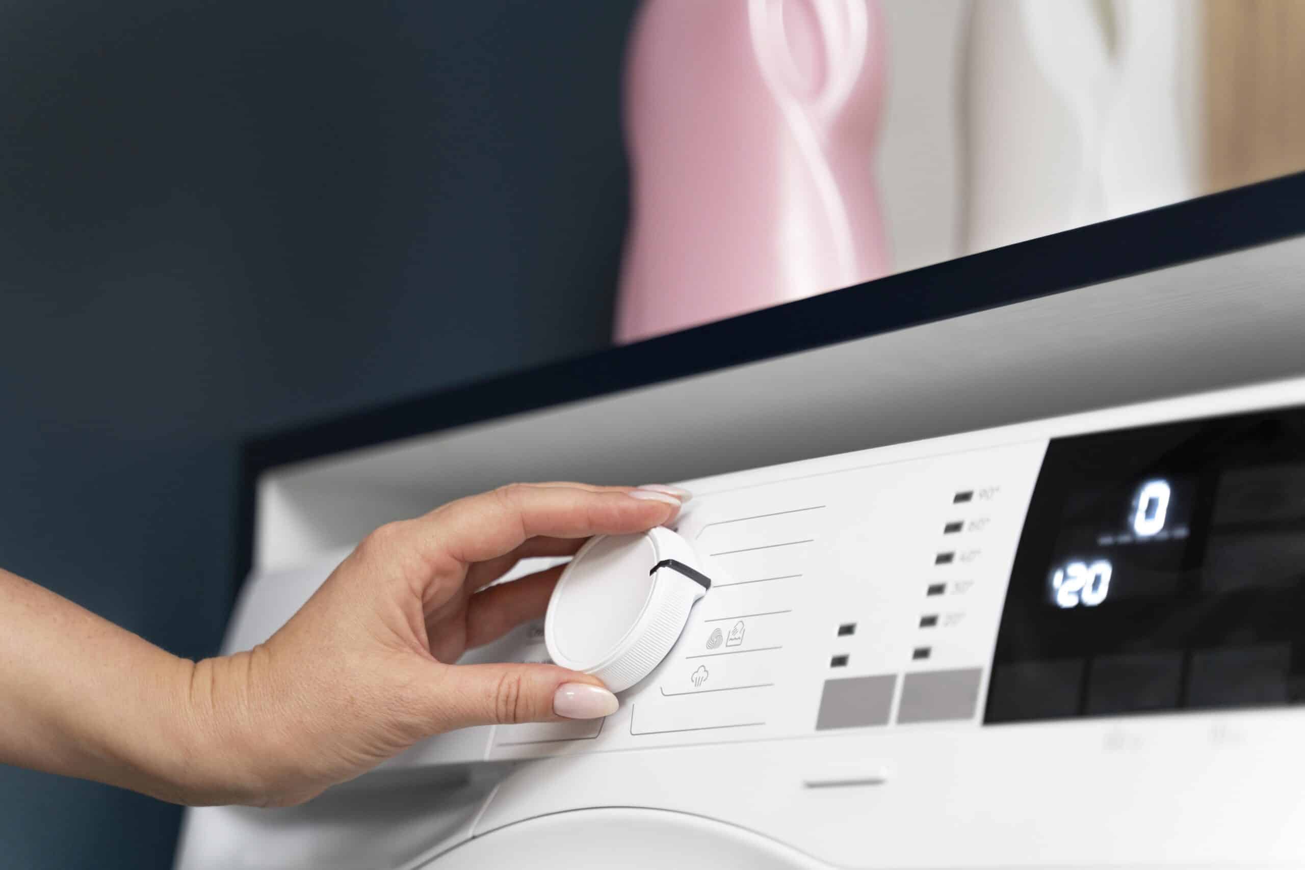 Woman choosing a wash program on a washing machine