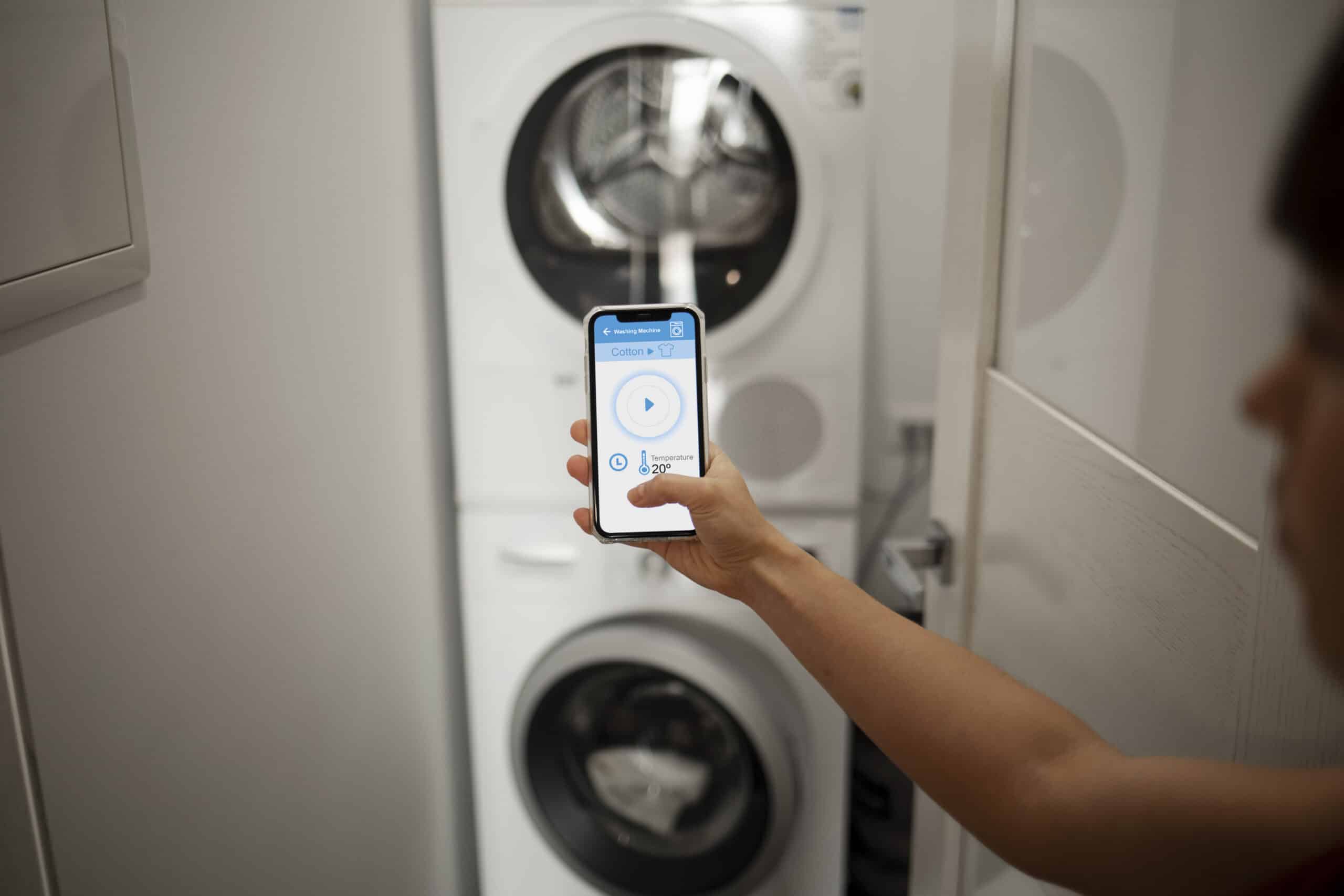 Young woman using the controls of a washing machine