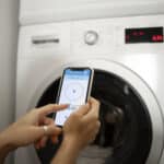 Jeune femme utilisant les commandes d'un appareil électroménager