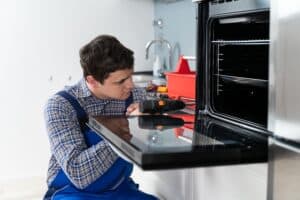 Technician repairing a GE oven that stopped heating