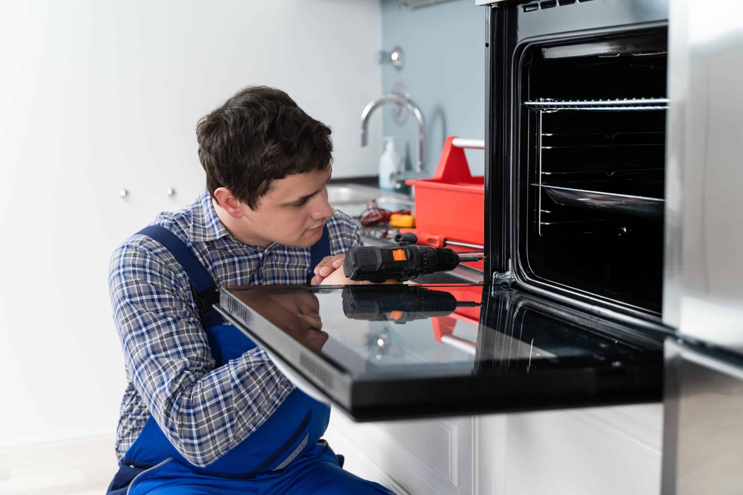 Technician repairing a GE oven that stopped heating
