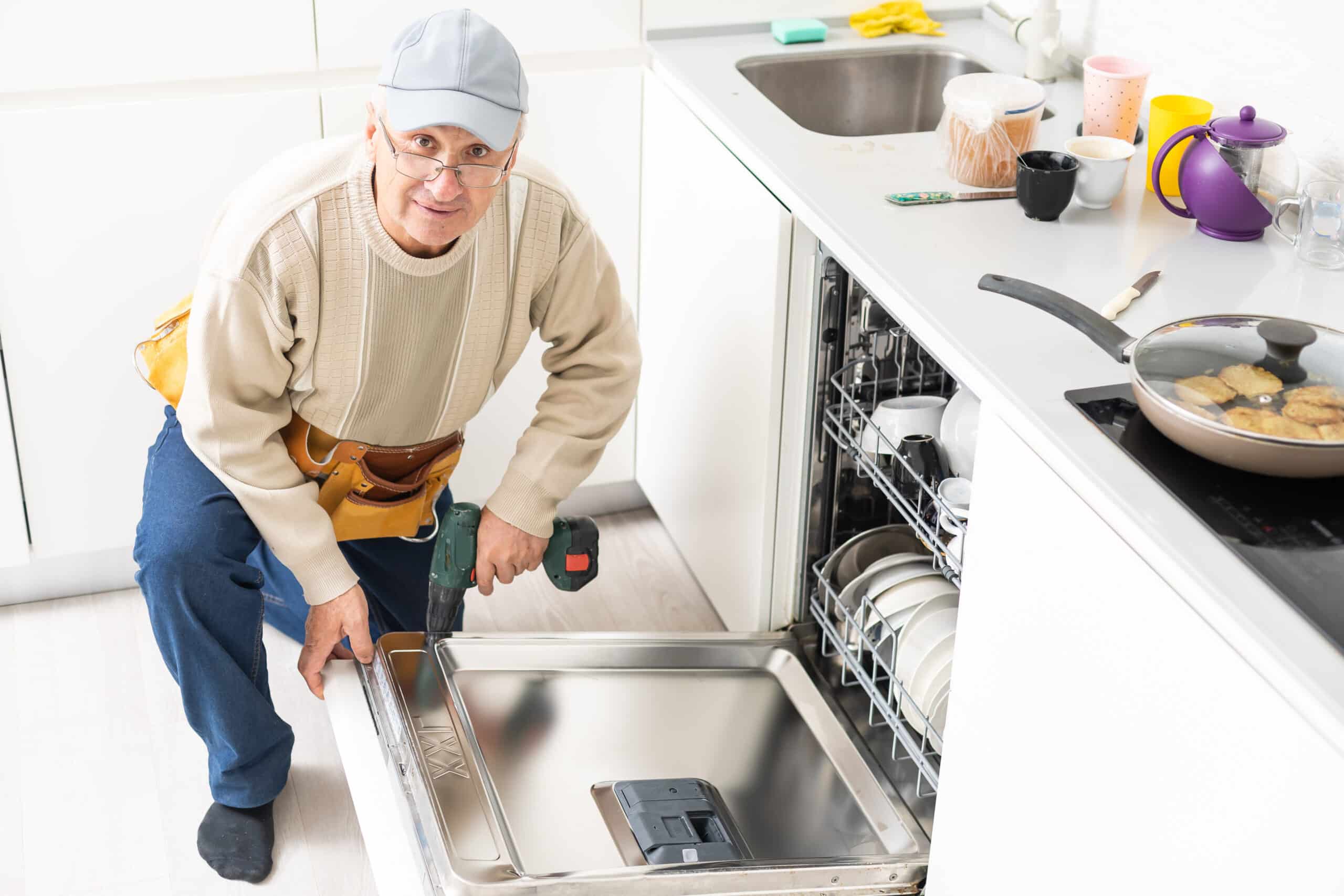 Technician repairing a Whirlpool dishwasher that is not draining