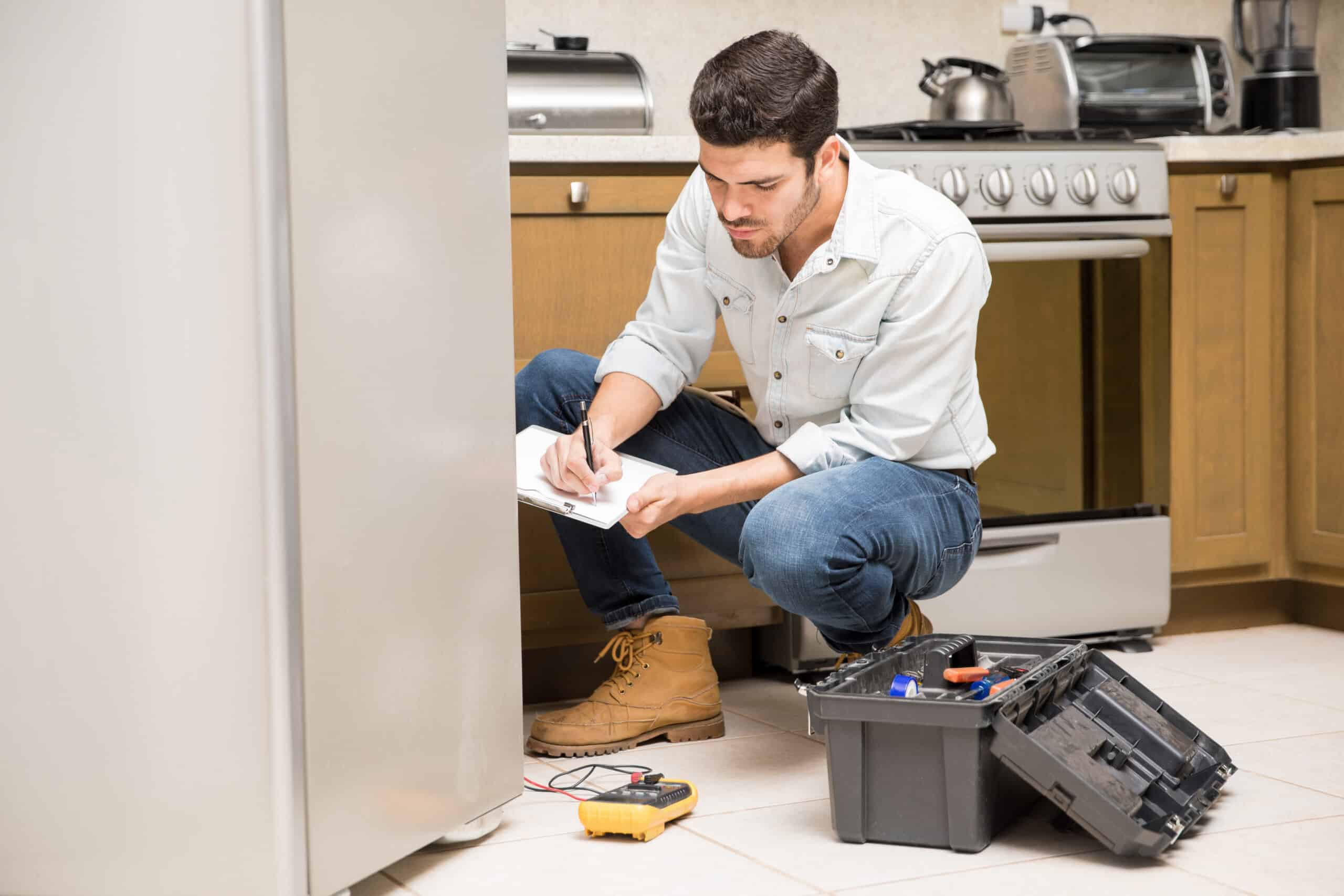 Technician filling out a repair report next to a refrigerator, illustrating LG refrigerator FF freezer fan error