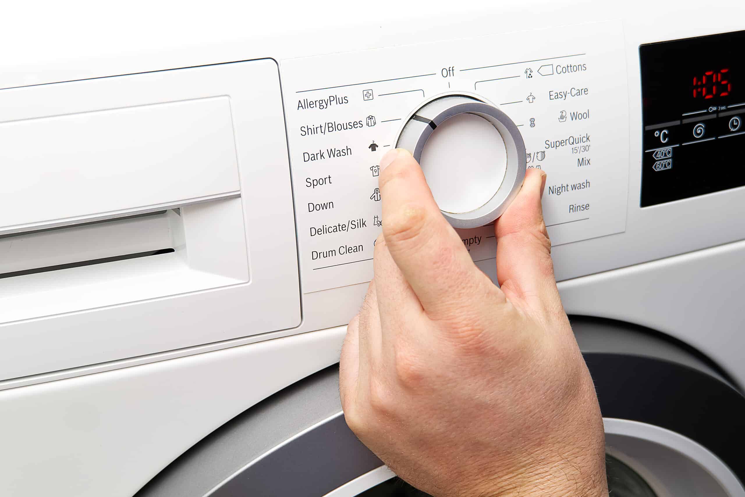 Man setting the program on a washing machine