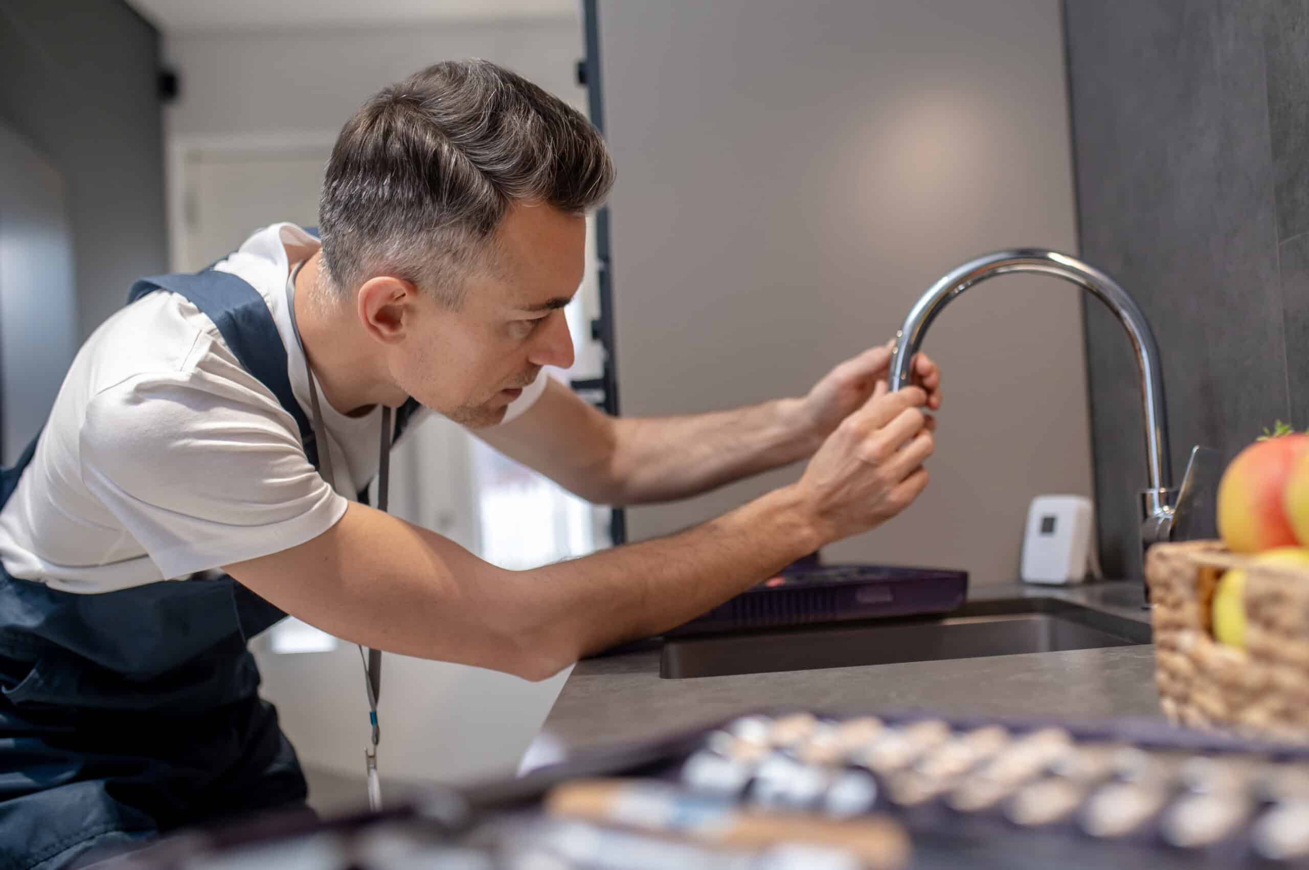 Technician checking a water supply valve related to a GE dishwasher H2O no-water-detected error