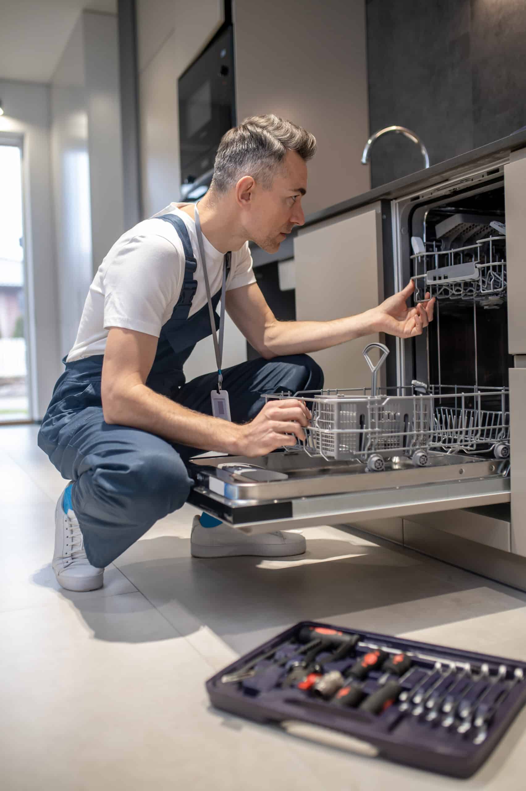 Technicien examinant la sonde de température d'un lave-vaisselle Whirlpool en panne, code erreur F1