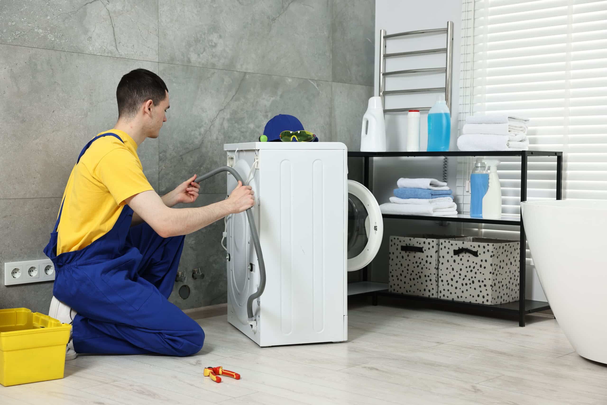 Technician examining a washing machine drain hose to fix a long drain time F9 E1 error