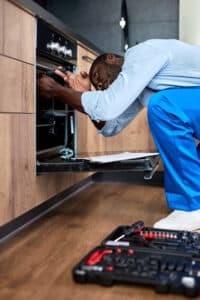 Technician repairing an oven that is not heating