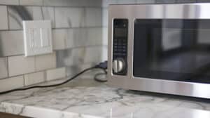 Microwave power cord plugged into a wall outlet
