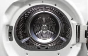 Open door of a white clothes dryer showing the empty stainless drum and its lifters